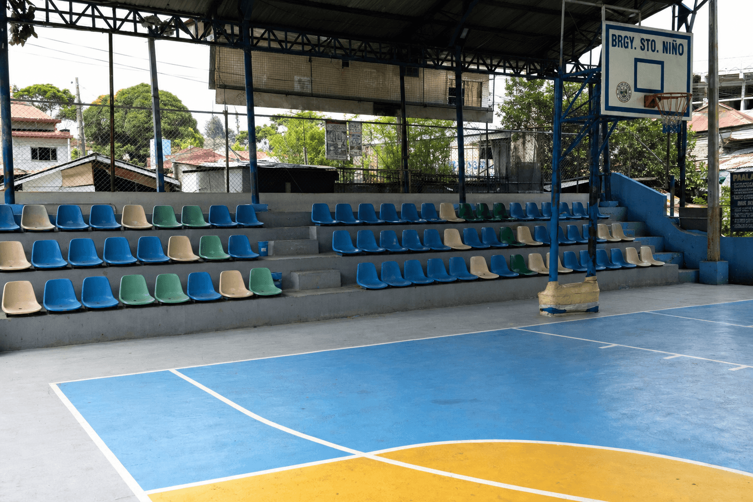 Small Philippine covered basketball court with modest stadium seating rows