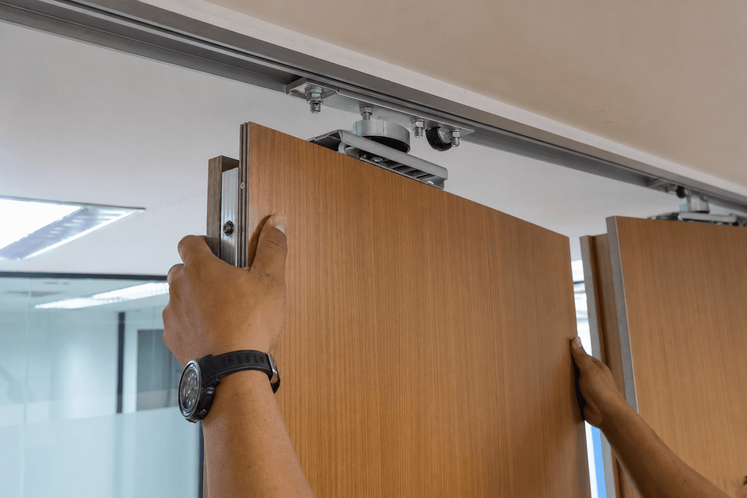 Operable wall installers mounting a track system in a commercial office space