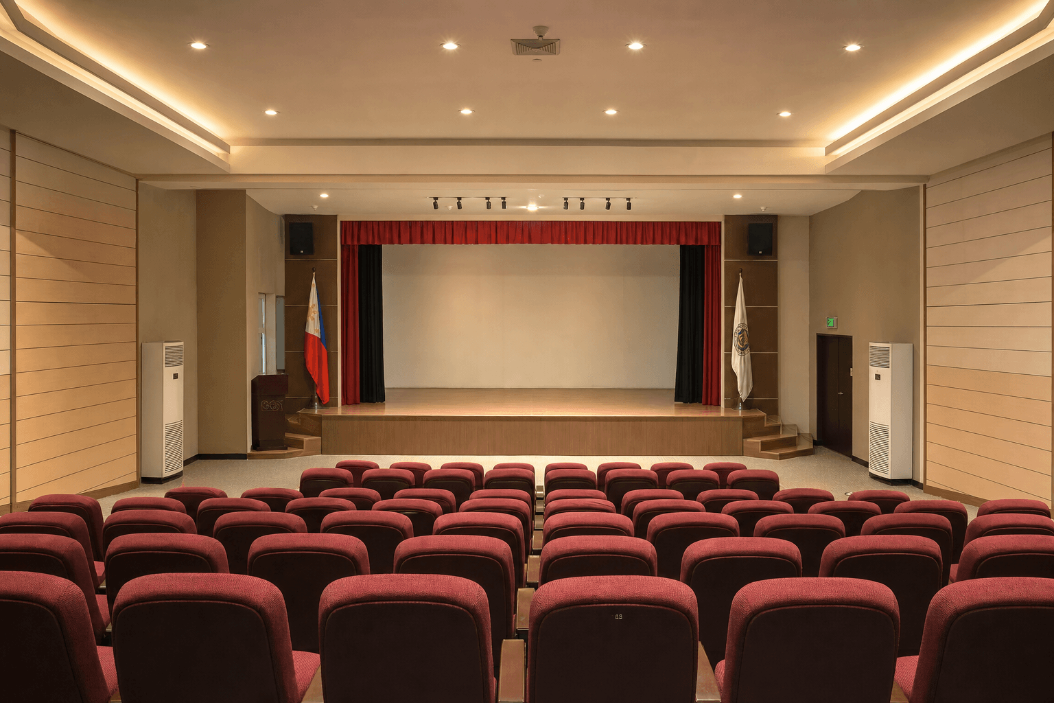 Small Philippine auditorium with modest theater seating rows and stage